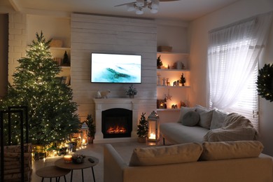 Photo of Stylish living room interior with TV set, Christmas tree and fireplace