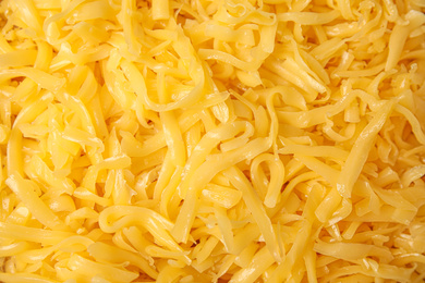 Delicious grated cheese as background, top view