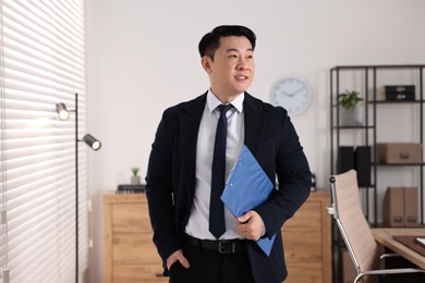 Portrait of happy notary with clipboard in office