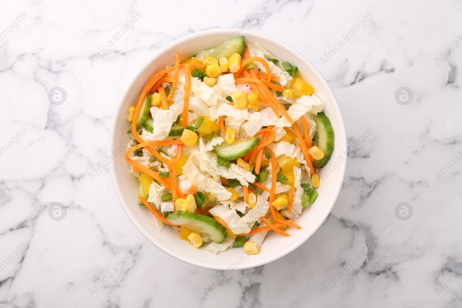 Photo of Tasty salad with Chinese cabbage, carrot, corn and cucumber in bowl on white marble table, top view