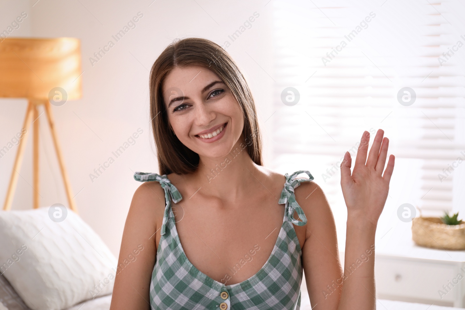 Photo of Young woman talking to his coworkers through video conference indoors, view from webcam