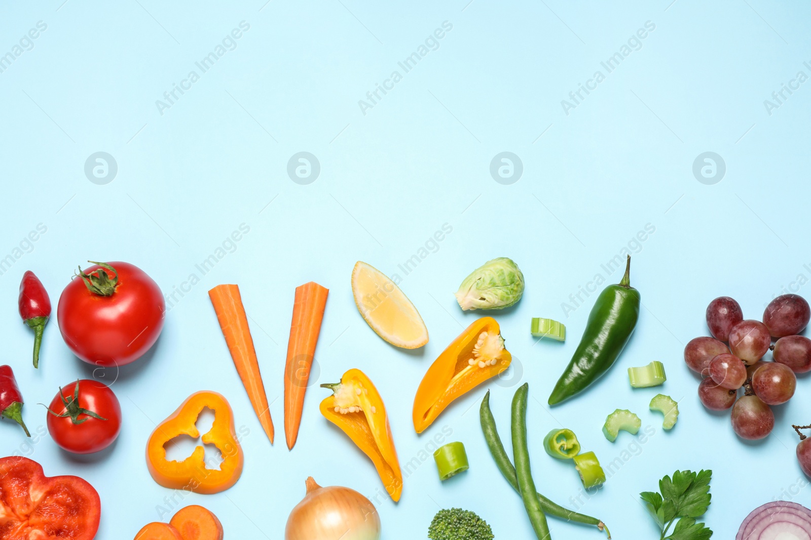 Photo of Fresh organic fruits and vegetables on light blue background, flat lay. Space for text