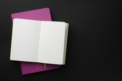 Photo of Notebooks on black background, top view. Space for text
