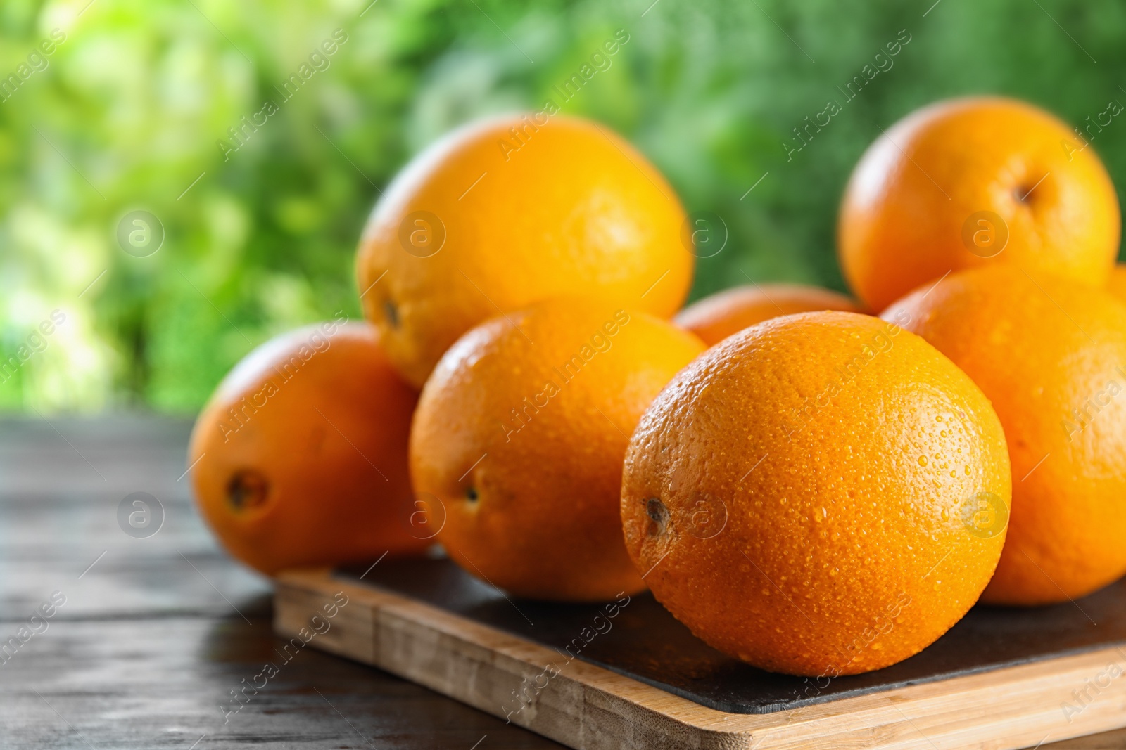 Photo of Fresh juicy oranges on wooden table. Space for text