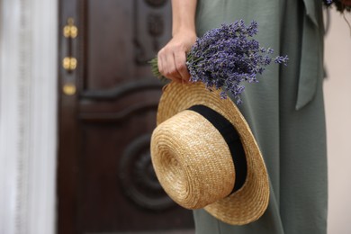 Photo of Young woman with lavender flowers and straw hat outdoors, closeup