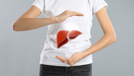 Woman and illustration of liver on light grey background, closeup