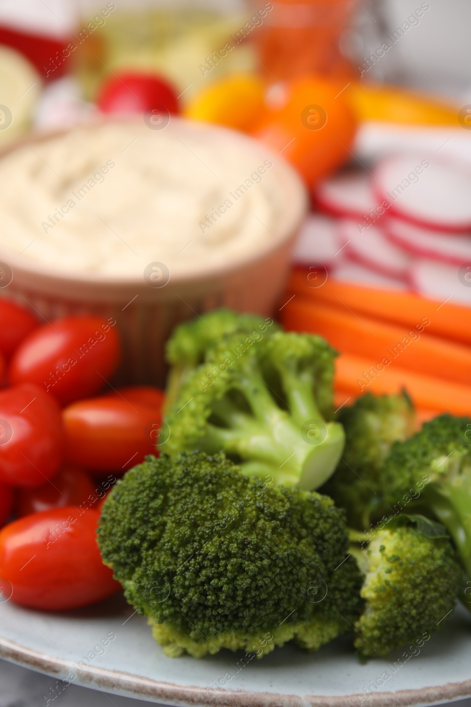 Photo of Plate with delicious hummus and fresh vegetables, closeup