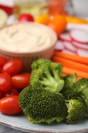 Photo of Plate with delicious hummus and fresh vegetables, closeup