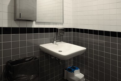 Public toilet interior with sink and mirror