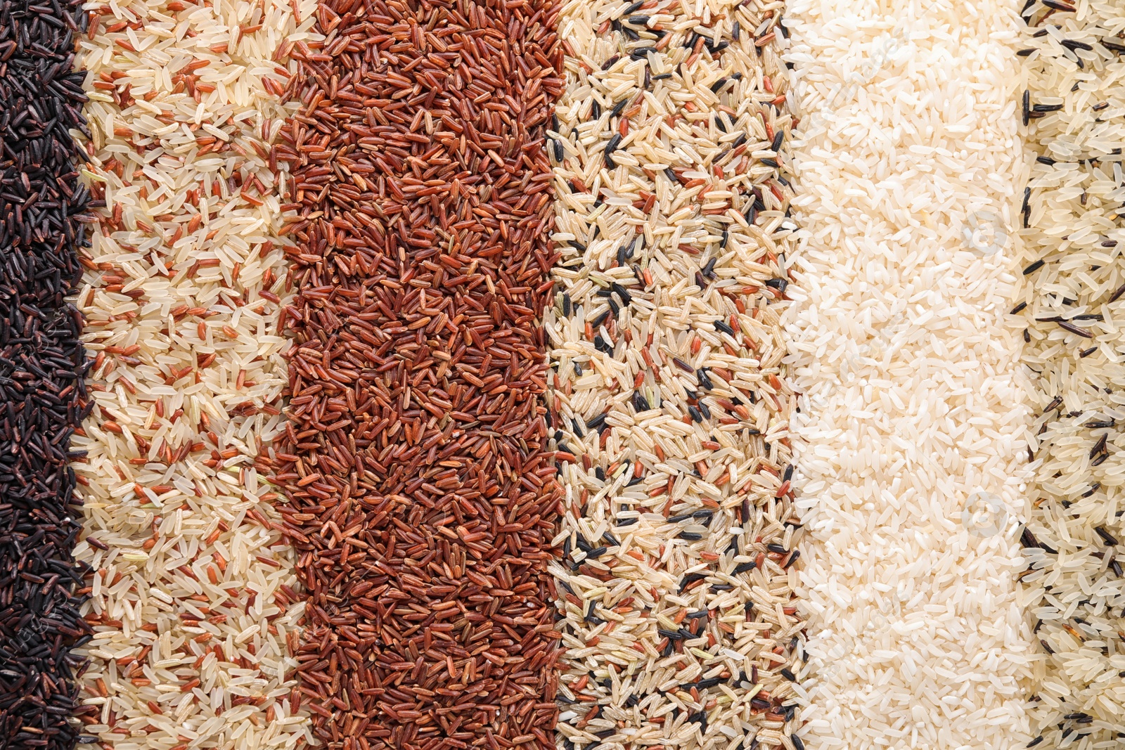 Photo of Different types of rice as background, top view