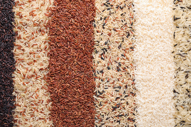 Photo of Different types of rice as background, top view