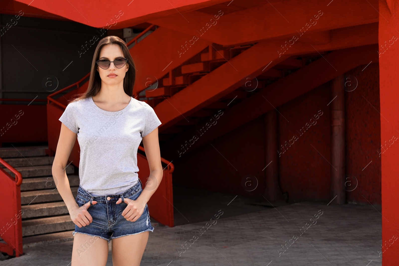 Photo of Young woman wearing gray t-shirt on street. Urban style