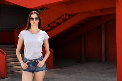 Young woman wearing gray t-shirt on street. Urban style