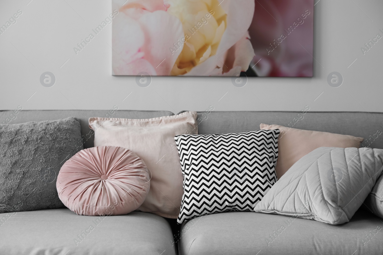 Photo of Comfortable sofa with different pillows indoors. Interior design