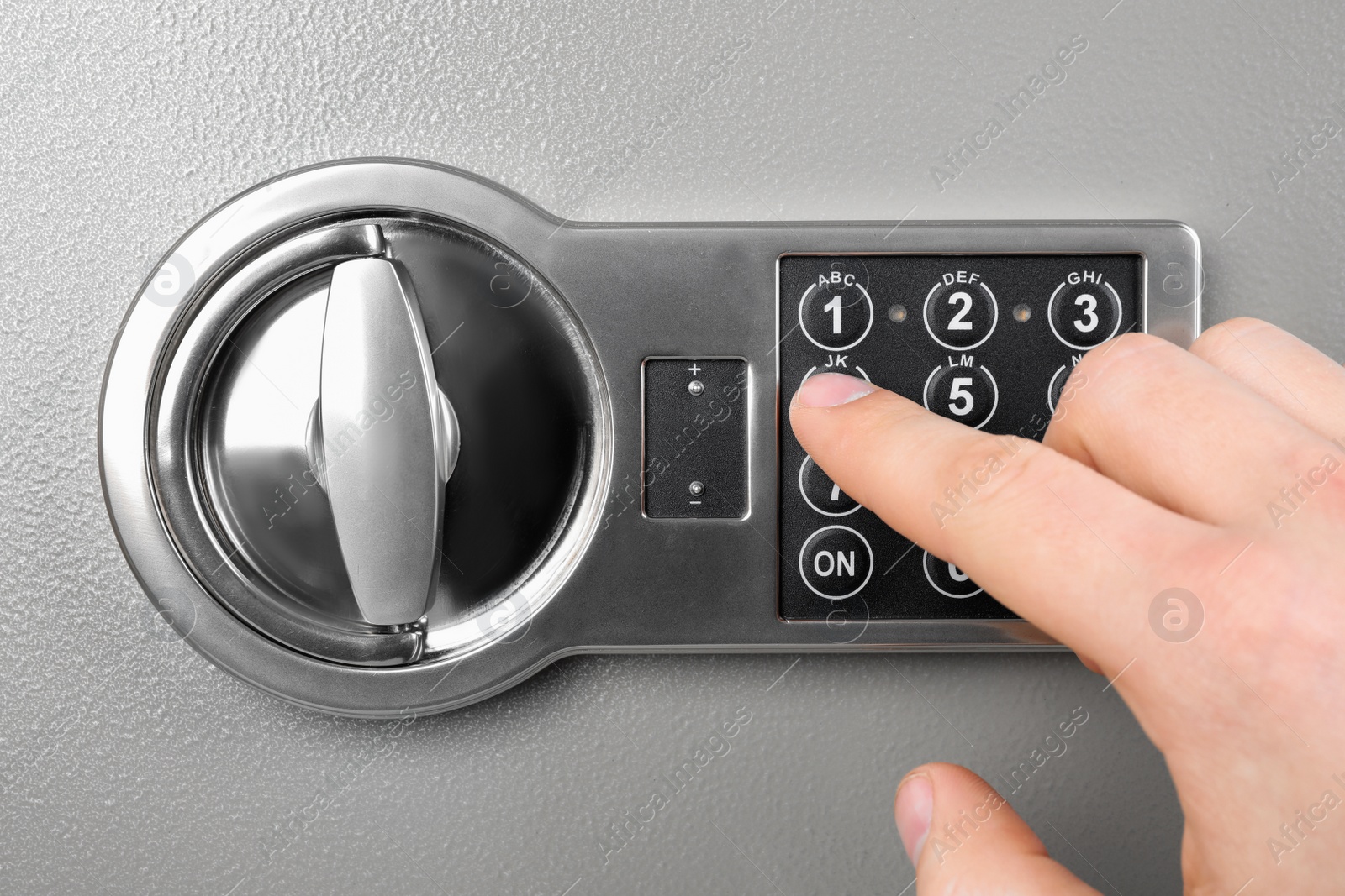 Photo of Man opening steel safe with electronic combination lock, closeup