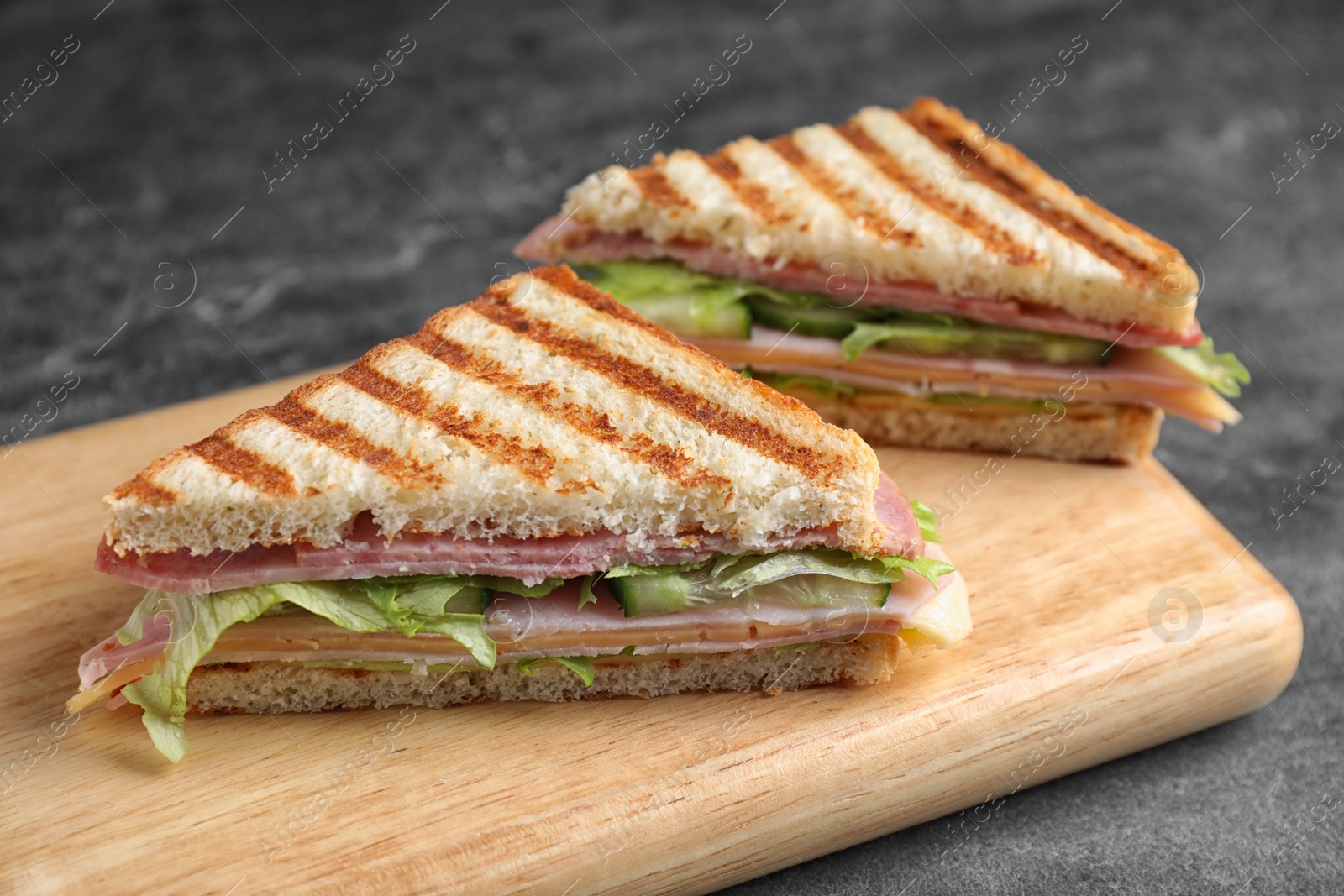 Photo of Tasty sandwich with ham on grey table, closeup