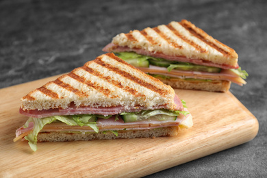 Photo of Tasty sandwich with ham on grey table, closeup