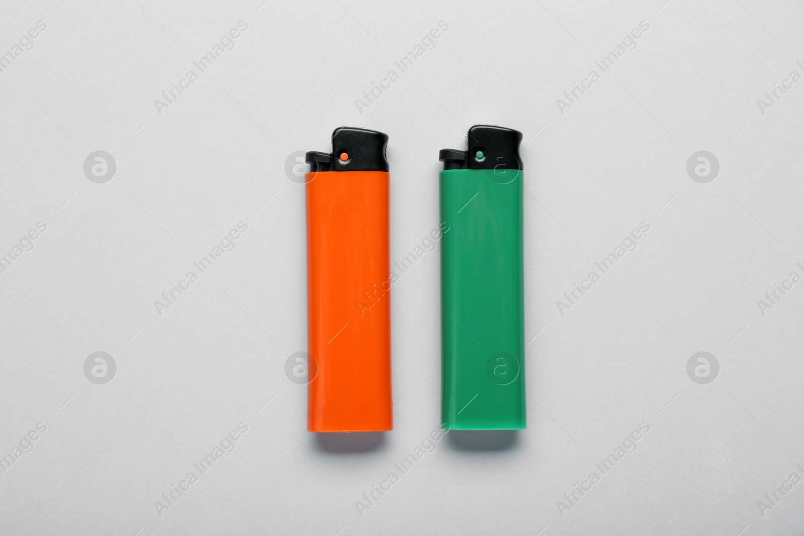 Photo of Stylish small pocket lighters on white background, flat lay