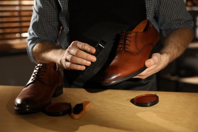 Photo of Master taking care of shoes in his workshop, closeup