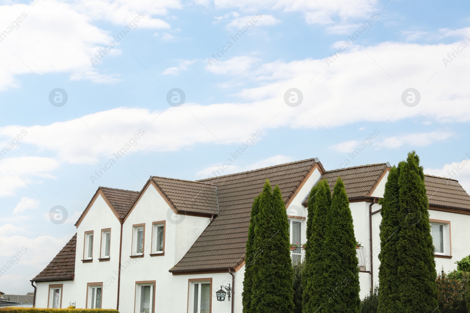 Photo of Beautiful house with brown roof against blue sky