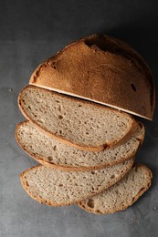 Photo of Freshly baked cut sourdough bread on grey table, top view