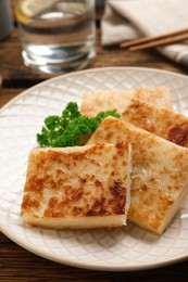 Photo of Delicious turnip cake with parsley served on wooden table
