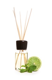 Photo of Aromatic reed air freshener and lime on white background