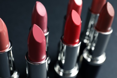 Set of different lipsticks on grey background, closeup. Cosmetic product