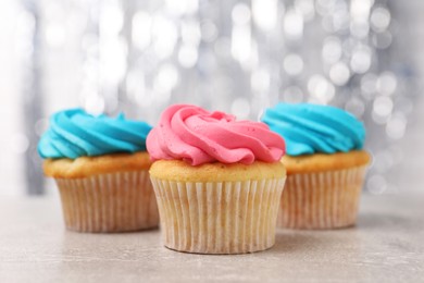 Photo of Delicious cupcakes with bright cream on grey table, closeup