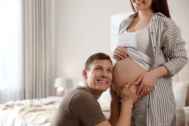 Young pregnant woman with her husband at home, closeup