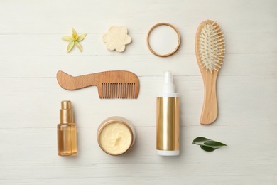 Flat lay composition with hair care cosmetic products on white wooden table