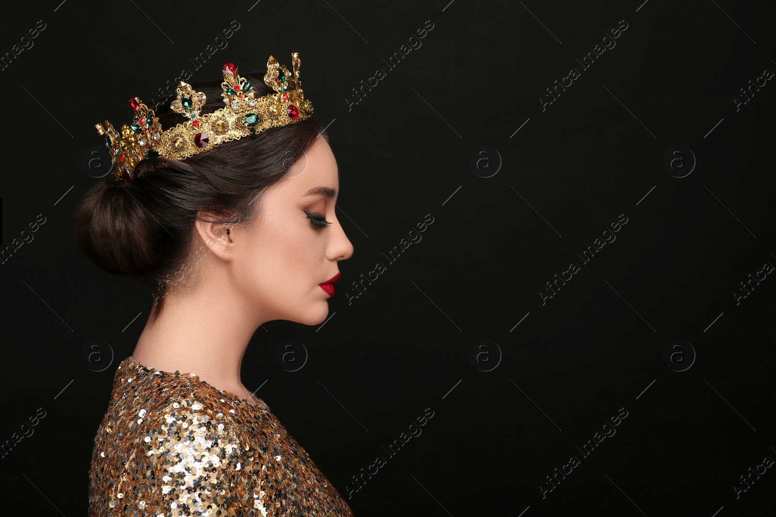 Photo of Beautiful young woman wearing luxurious crown on black background, space for text