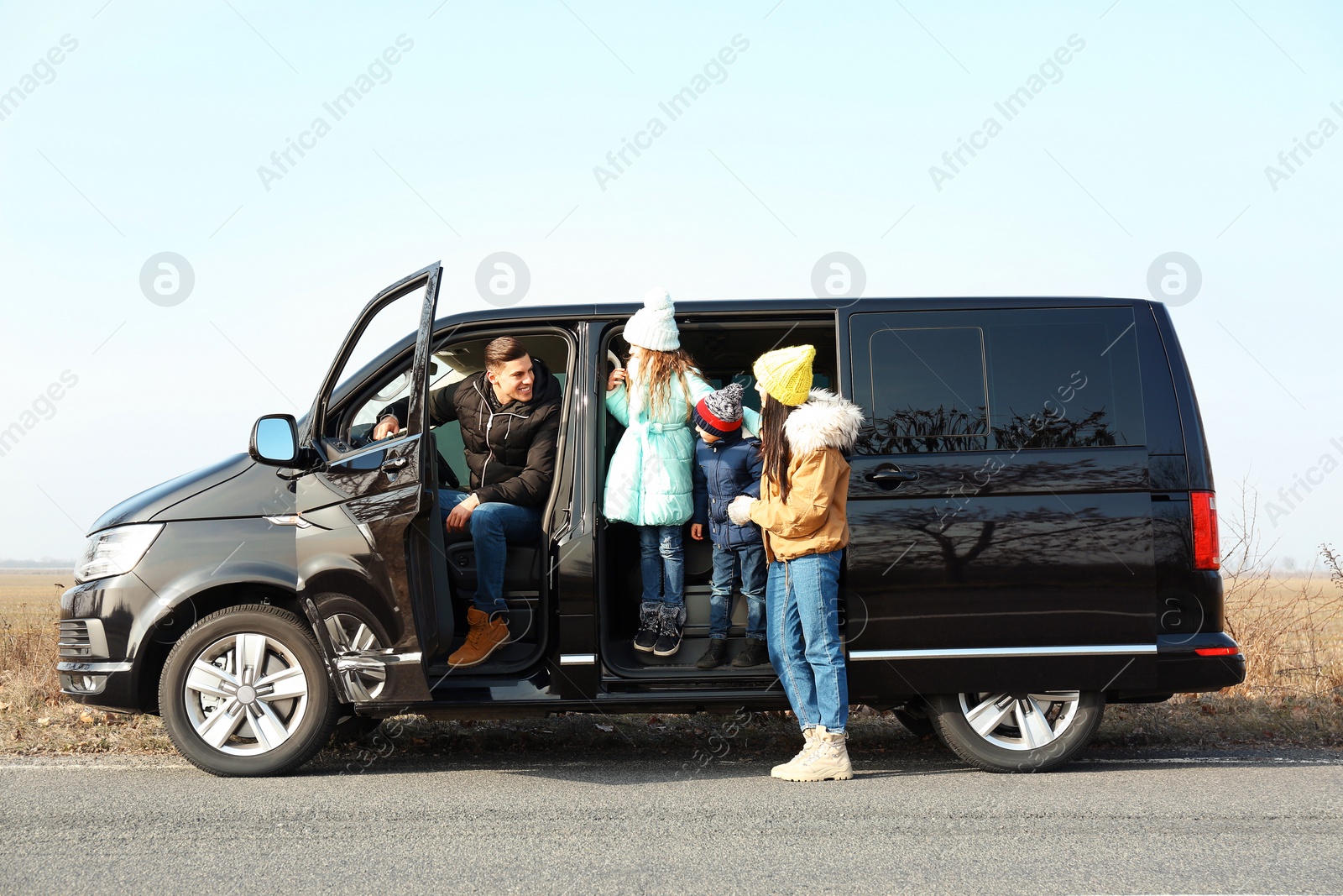 Photo of Happy family with little children in modern car on road