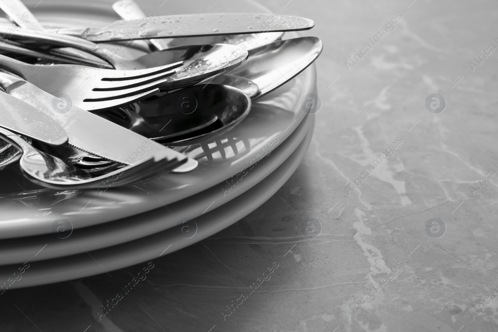 Photo of Different clean kitchenware on light grey marble table, closeup. Space for text