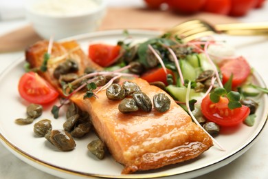 Photo of Delicious salmon with salad and capers on table, closeup