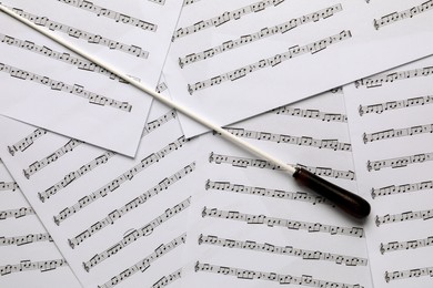 Photo of Conductor's baton on sheet music, flat lay