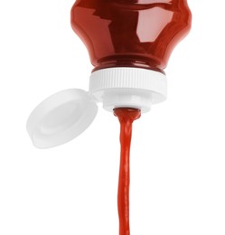 Photo of Pouring tasty red ketchup from bottle isolated on white