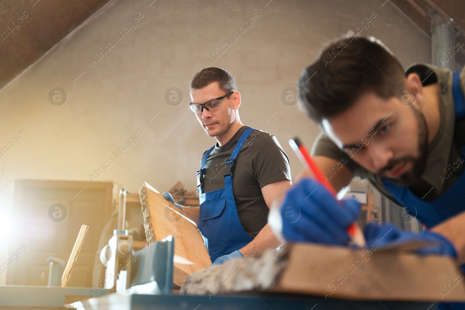 Photo of Professional carpenters working with wood in shop