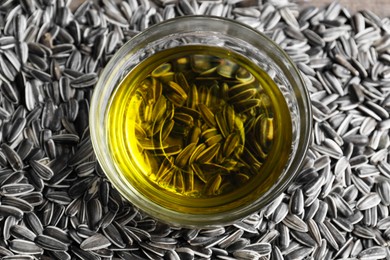 Photo of Sunflower oil in glass bowl on seeds, above view