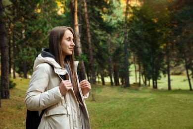 Photo of Woman with backpack in beautiful mountain forest. Space for text