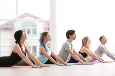 Photo of Group of people practicing yoga indoors