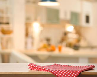 Image of Red towel on wooden table in kitchen. Space for text