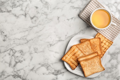 Photo of Plate with toasted bread and cup of tea on light background, top view