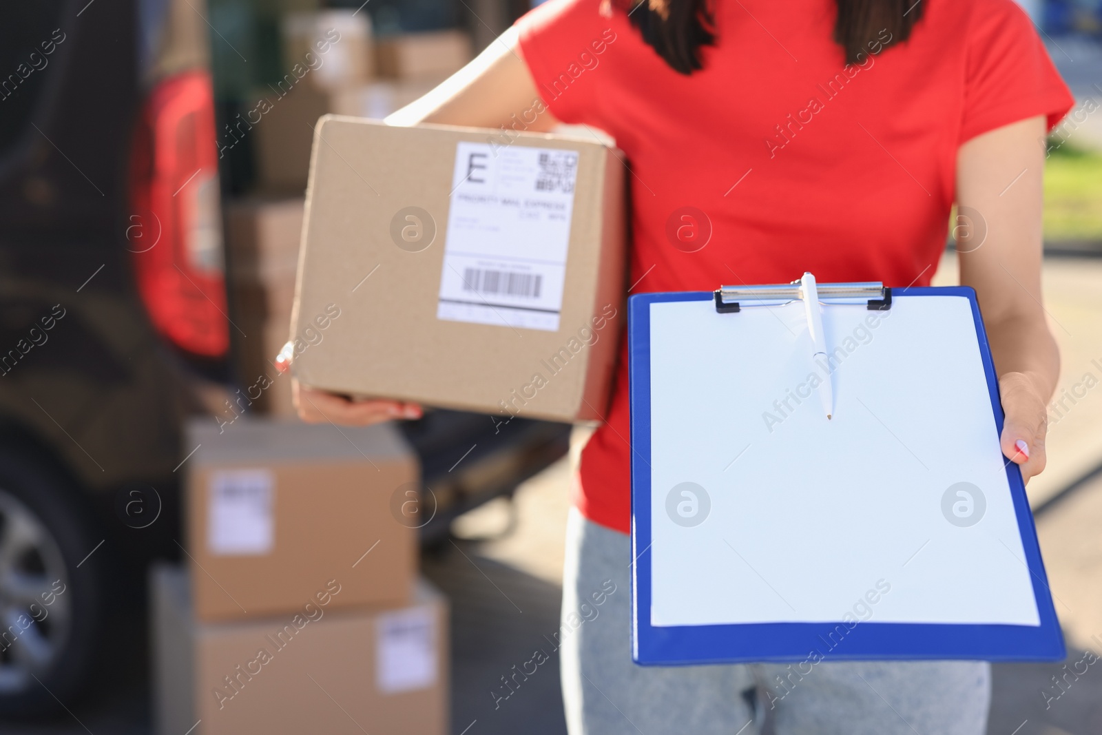 Photo of Courier with parcel and clipboard near delivery van outdoors, closeup. Space for text