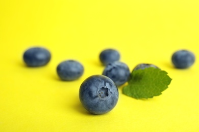 Photo of Tasty ripe blueberry on color background, closeup