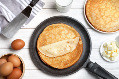 Photo of Flat lay composition with thin pancakes on white wooden table