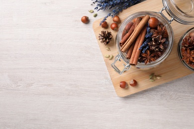 Photo of Aroma potpourri with different spices on white wooden table, flat lay. Space for text