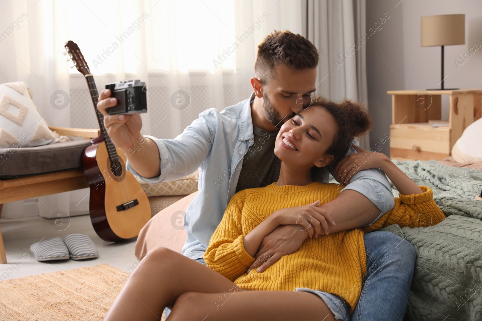 Photo of Lovely couple taking selfie on floor in bedroom