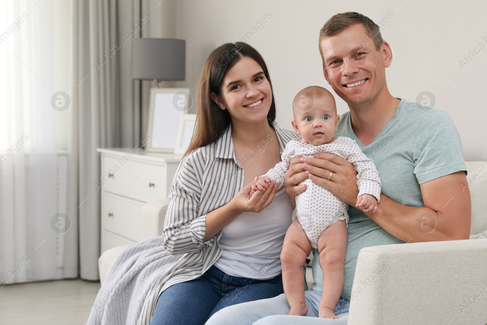 Photo of Happy family with their cute baby in living room at home