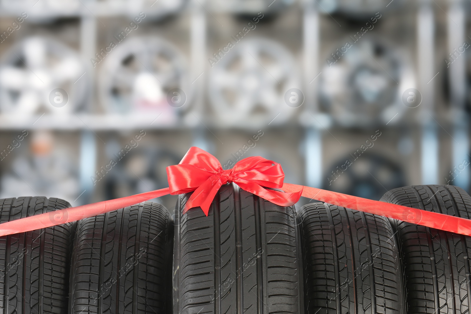 Image of Car tires tied with red ribbon in auto store
